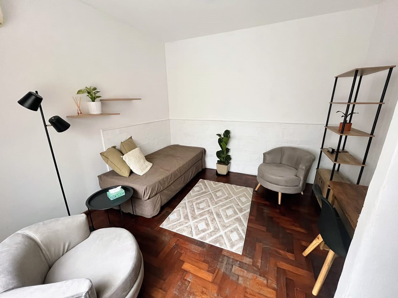 Consultorio 2 de Espiral Sur, con sillones, estantería y lámpara